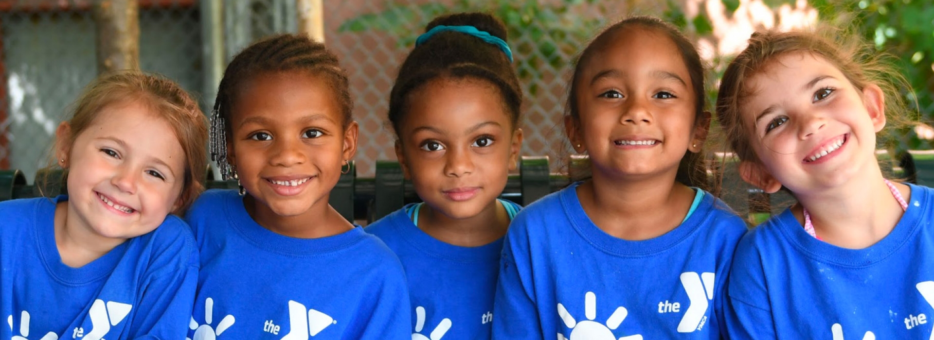 Five young girls smiling at the Dodge YMCA day camp.