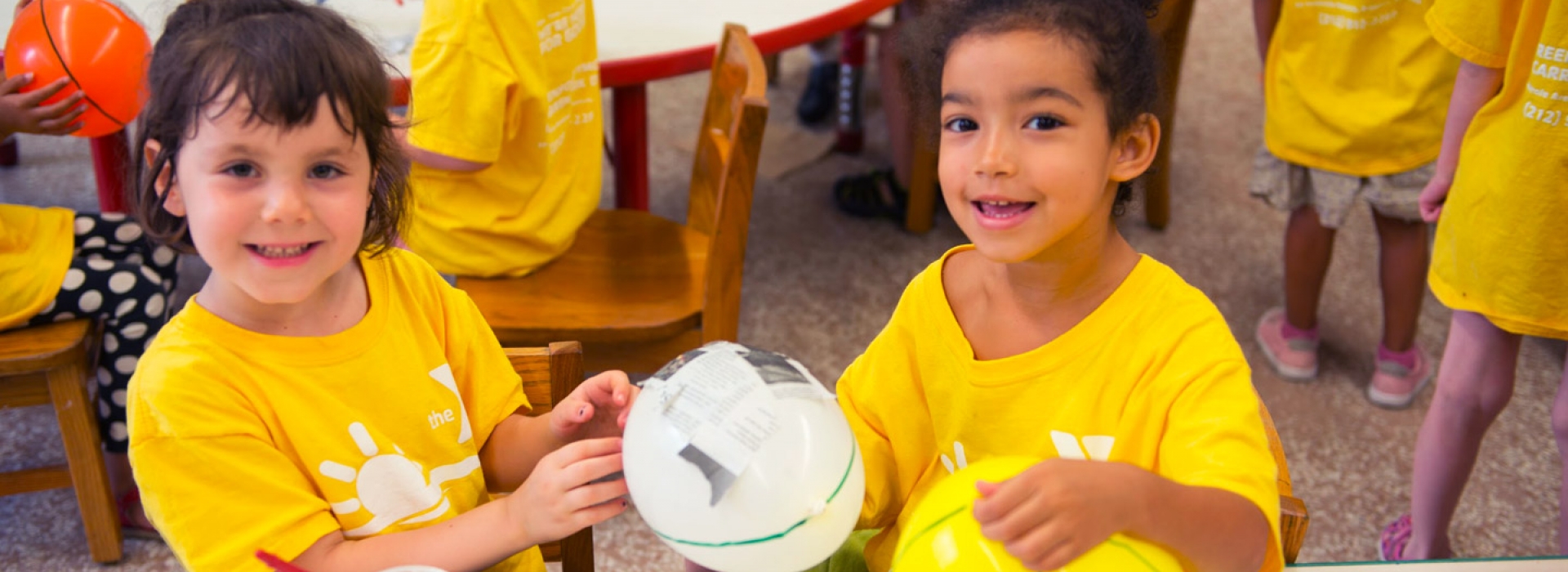 Two kids work on crafts at the Greenpoint YMCA summer day camp.