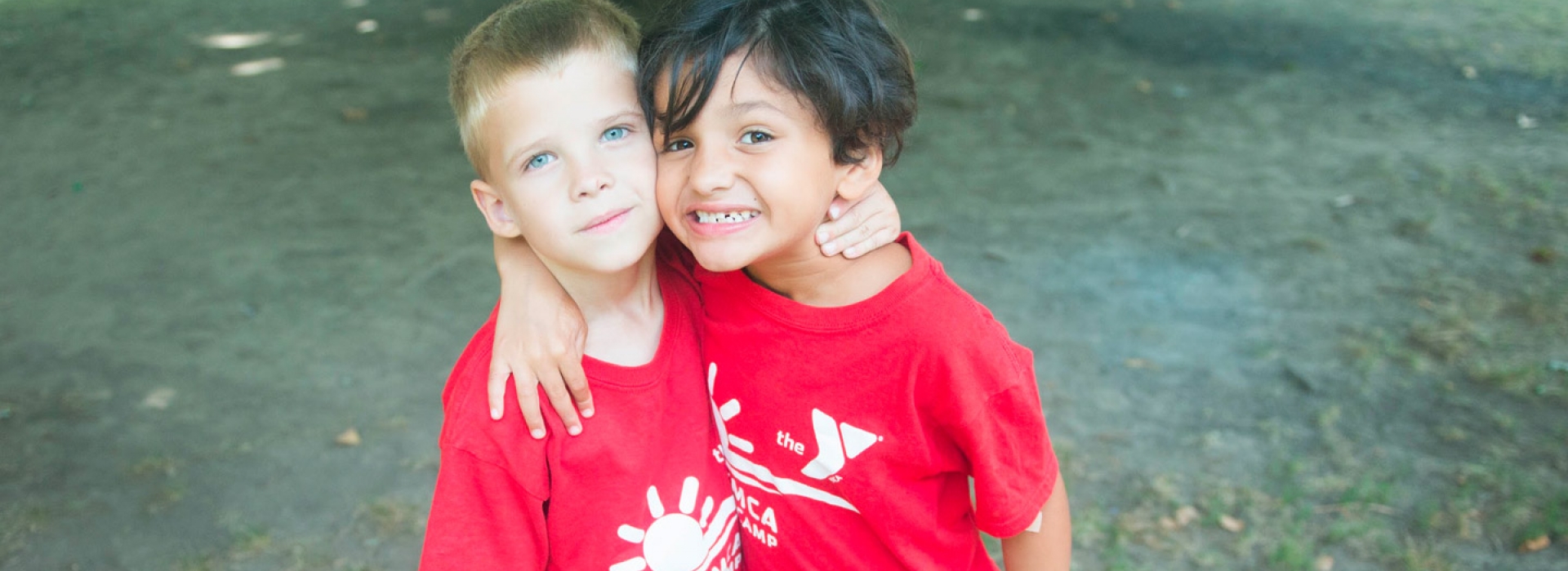 Two boys hug each other at the Ridgewood YMCA summer day camp.
