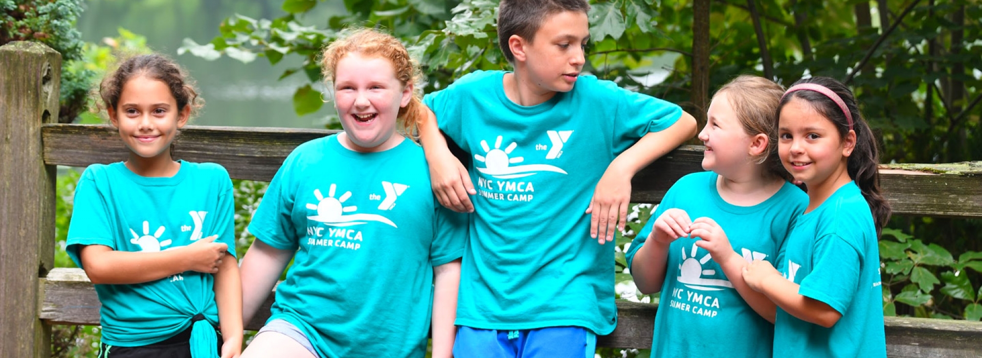 A group of kids standing outside at a YMCA summer day camp.