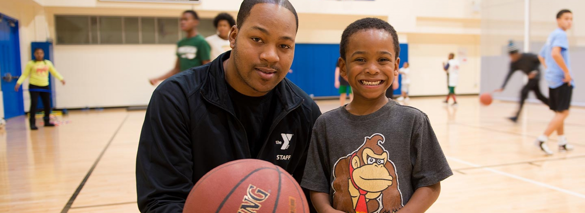 Young boy with basketball instructor at YMCA