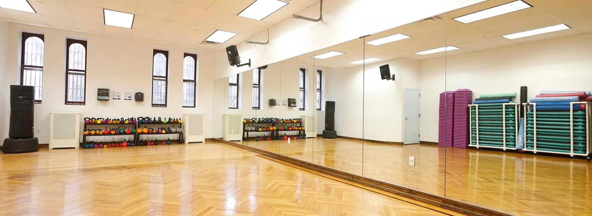 Group fitness studio with kettlebells and mirrors at Park Slope Armory YMCA