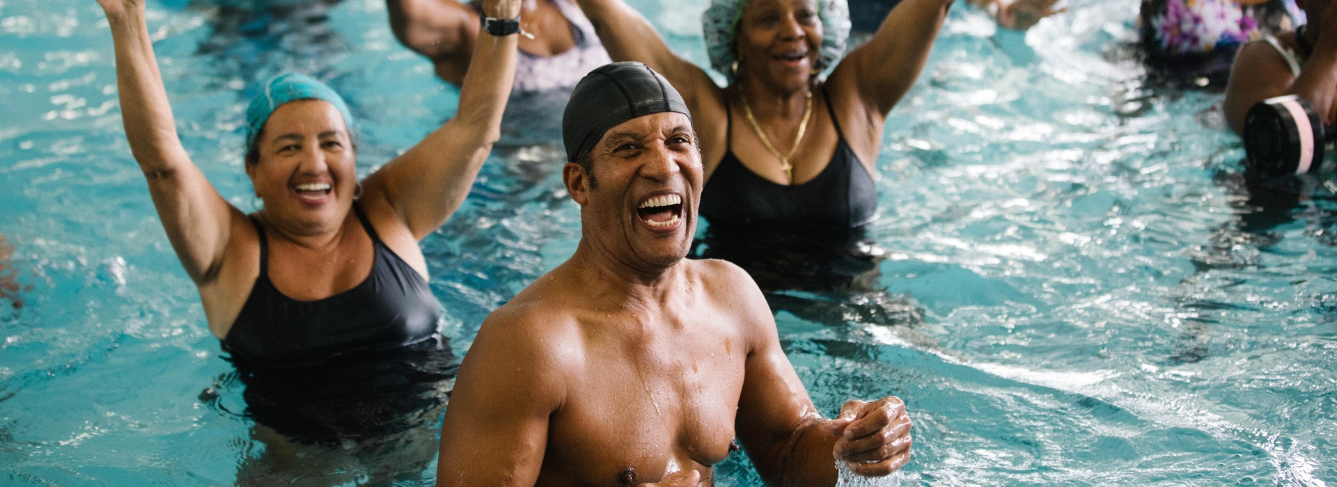 Class smiling during aqua aerobics class at Bronx YMCA indoor pool