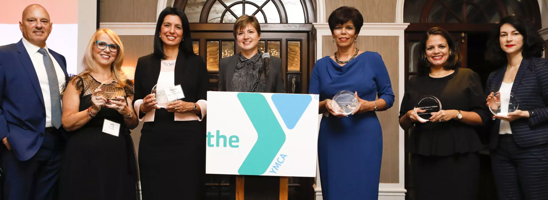 A group of people show off their awards at the Hispanic Achievers event for the YMCA of Greater New York.