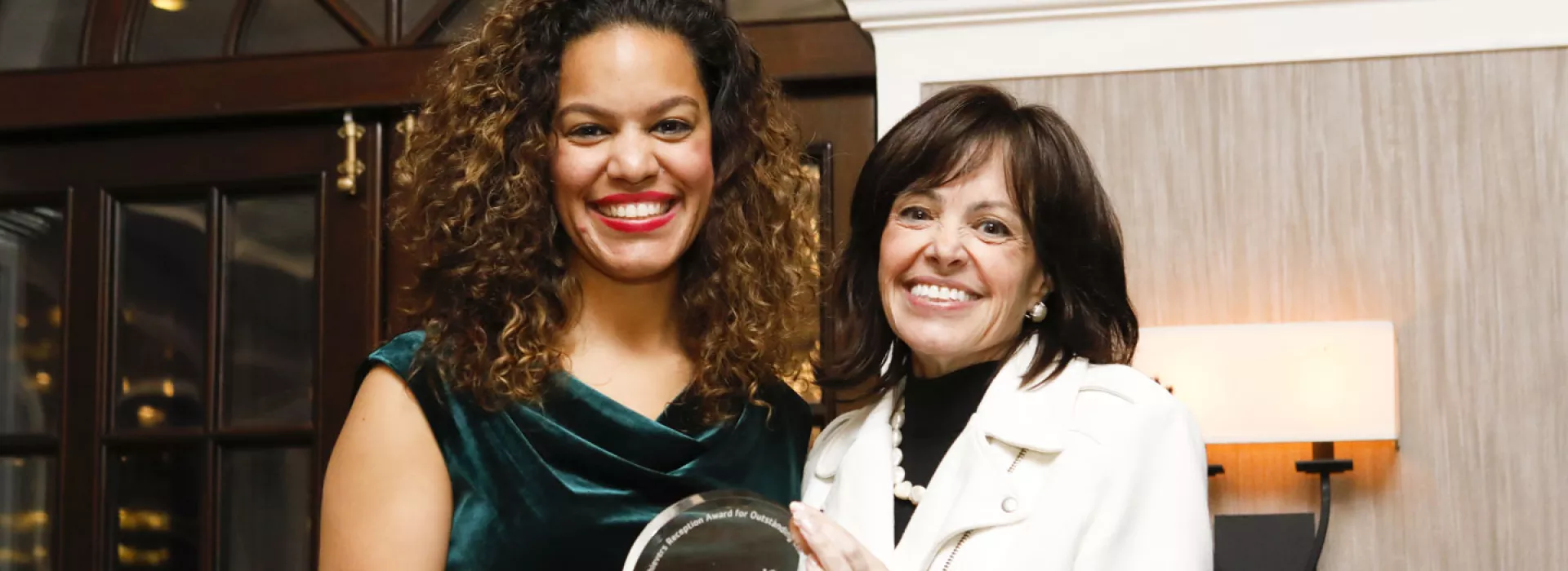 Two women show off an award at the Hispanic Achievers event for the YMCA of Greater New York.