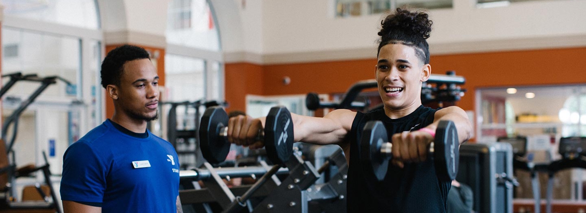 Man lifts weights with personal trainer