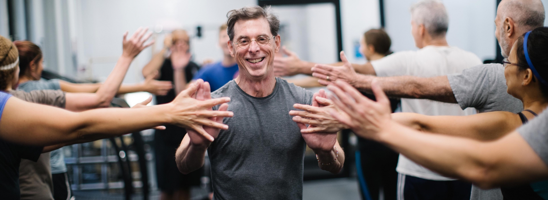 Man high fives classmates in YMCA fitness class