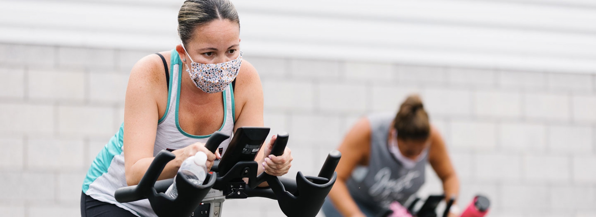 Two participants in an outdoor spin class at the YMCA.