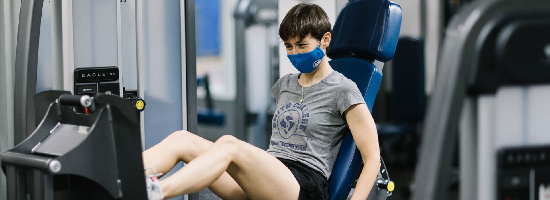 A woman in a mask doing strength training.