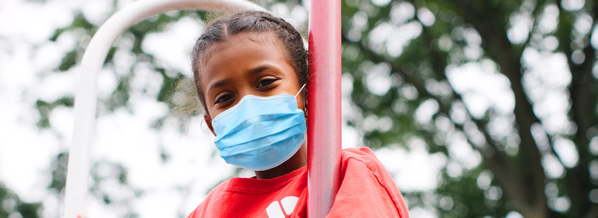 A girl in a mask playing outside at Y camp