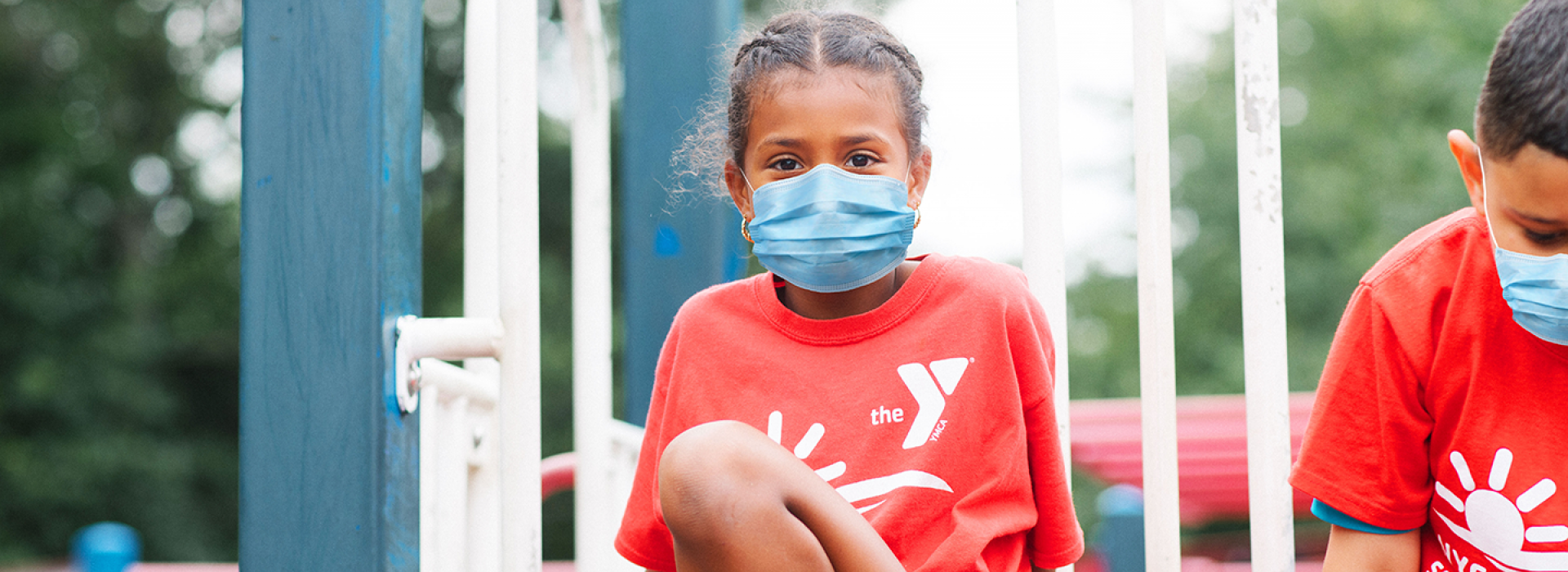 A girl in a mask playing outside at Y camp