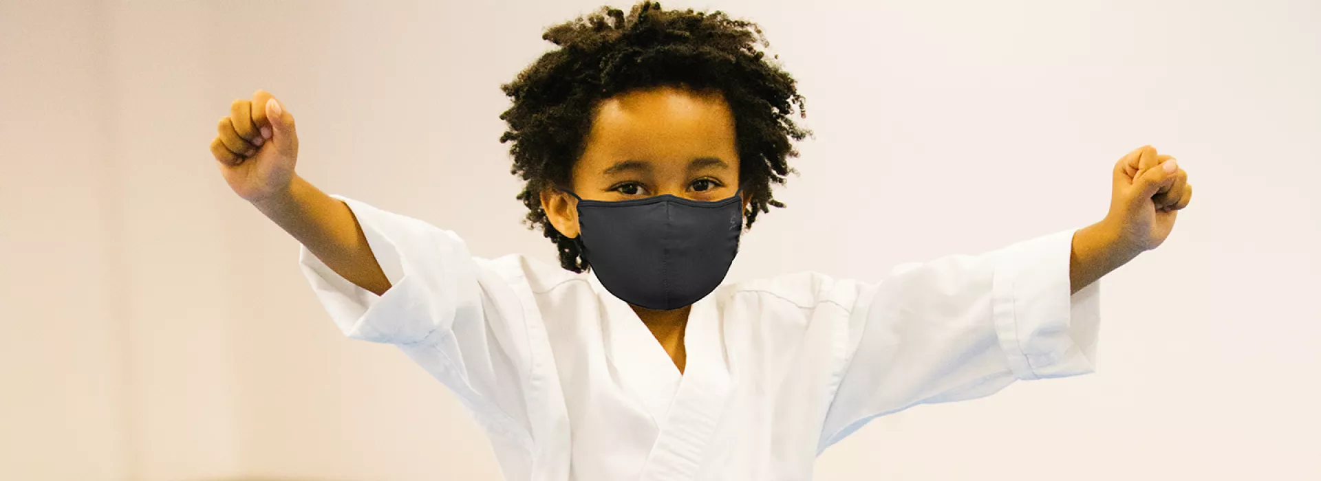 A boy wearing a mask in karate class at the YMCA