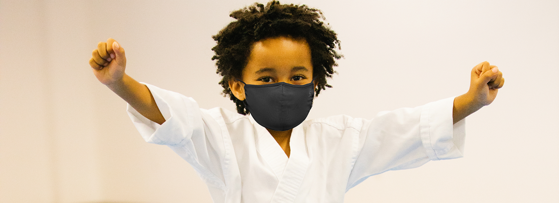 A boy wearing a mask in karate class at the YMCA