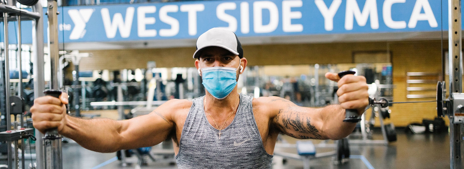 Man wearing a mask and working out in the gym