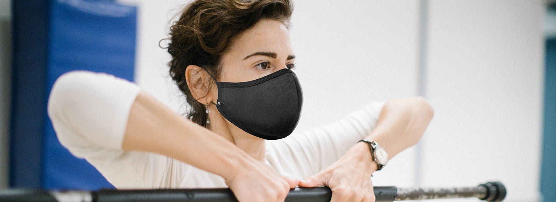Woman working out with a mask on in a group exercise class