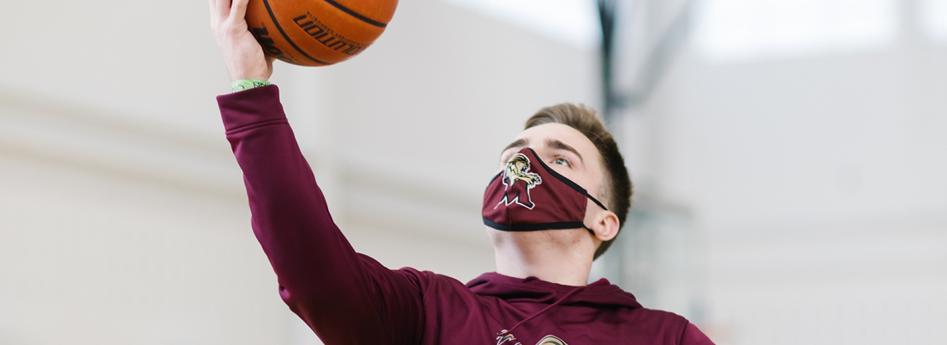 A boy wearing a mask playing basketball