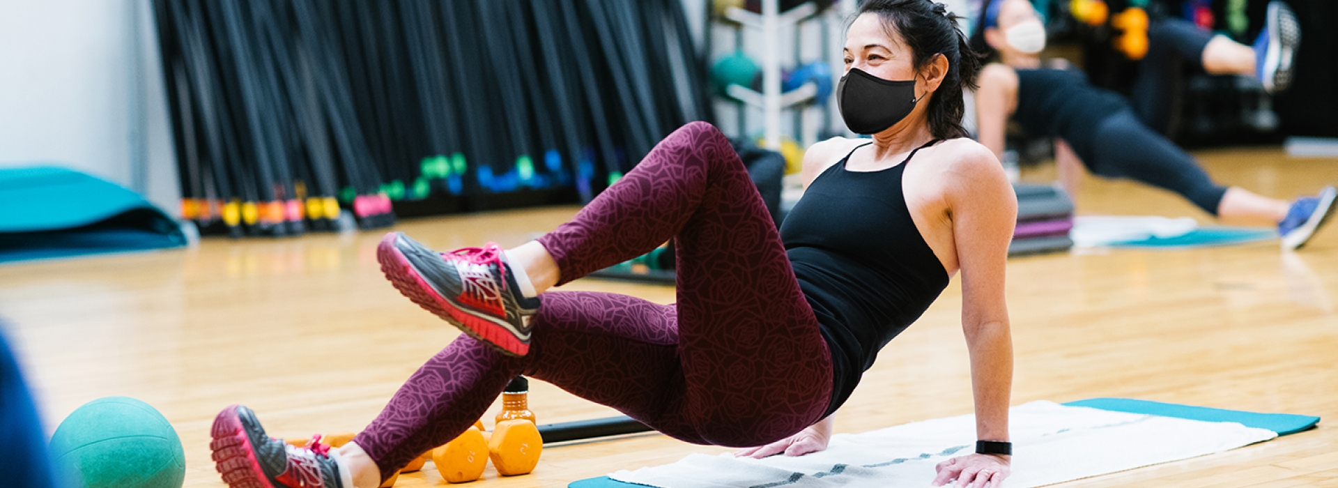 A woman wearing a mask participating in a group exercise class