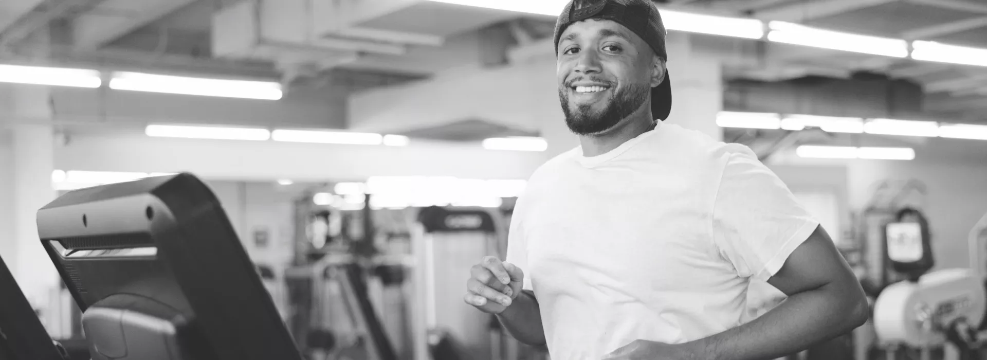 guy jogs on treadmill smiling