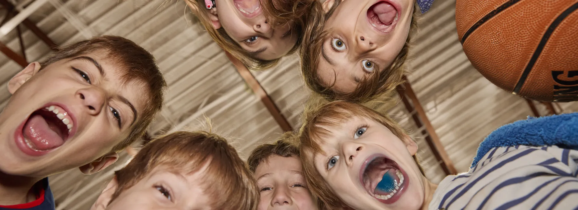 Kids look down into camera, yelling with excitement.